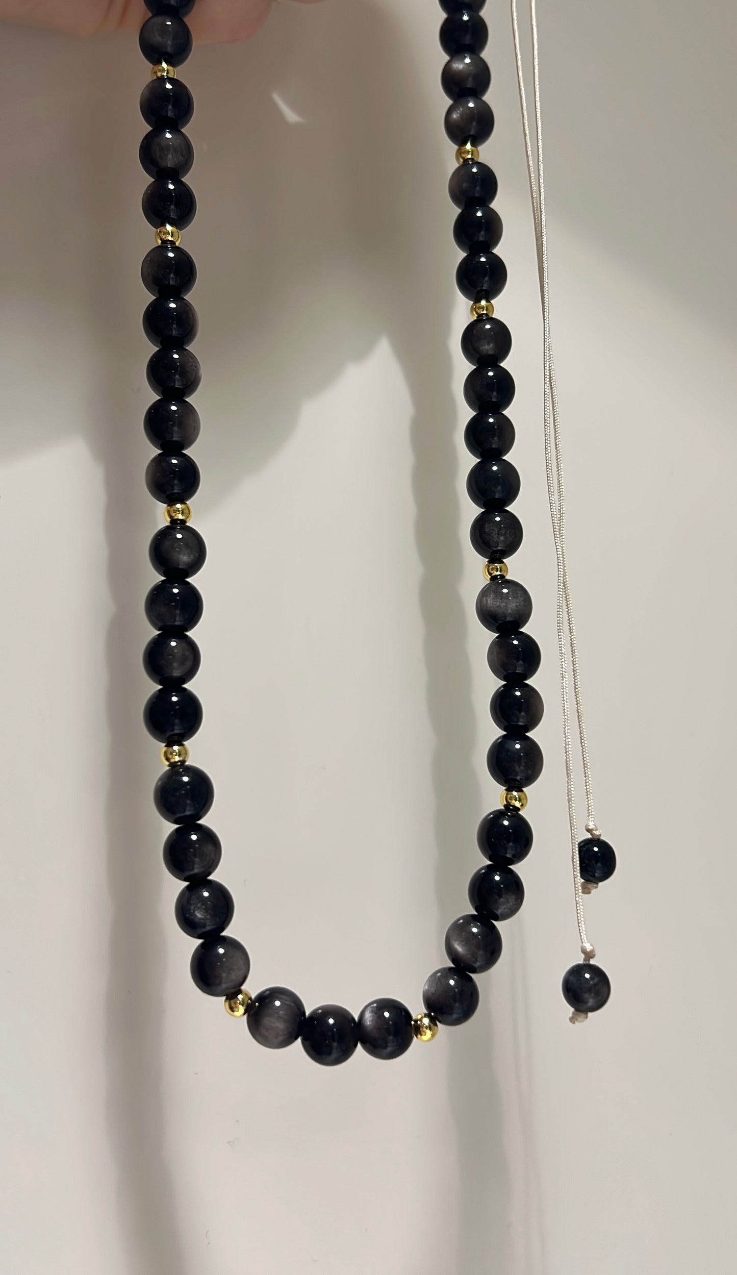 Black beaded necklace on a white background