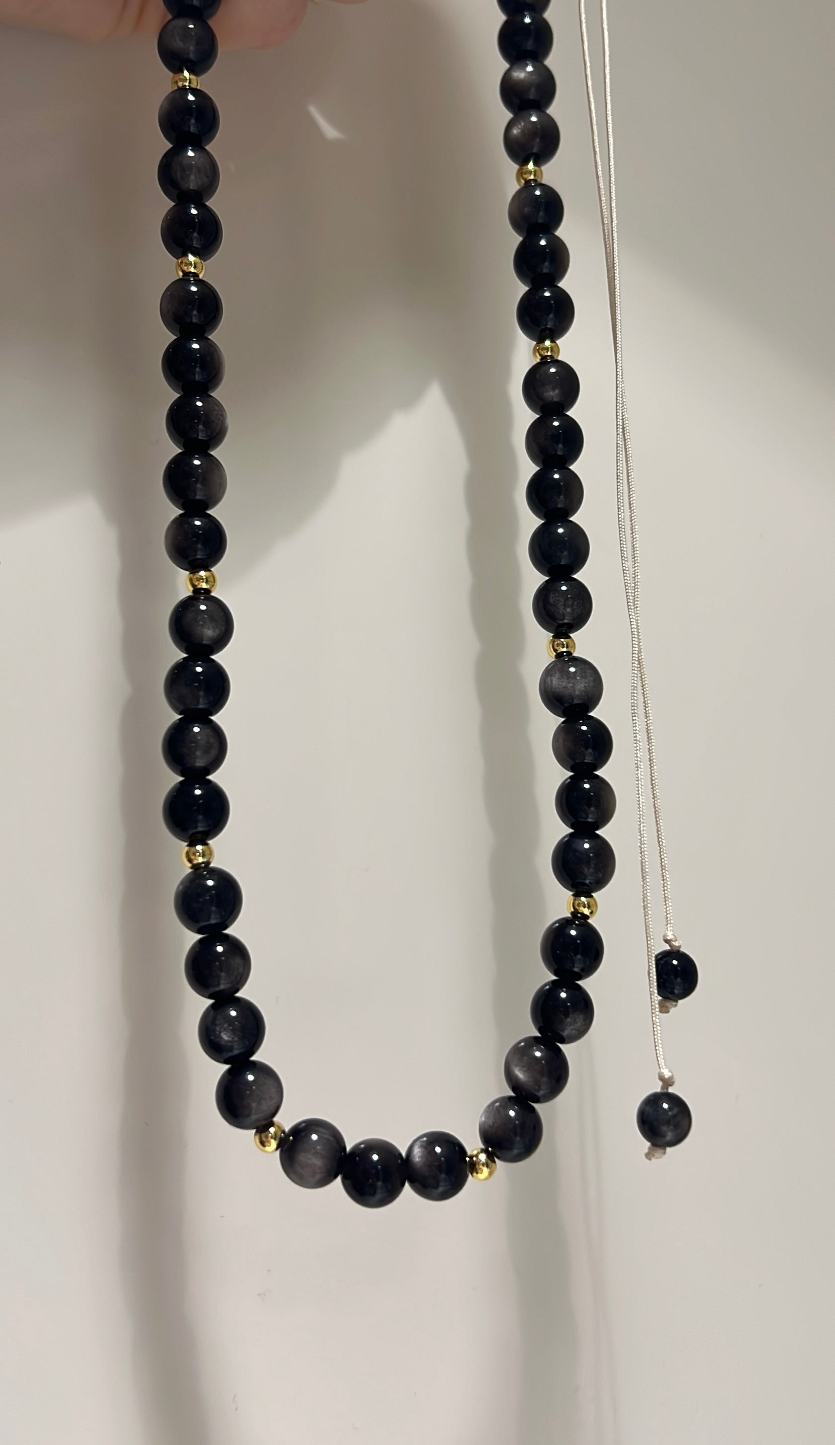 Black beaded necklace on a white background