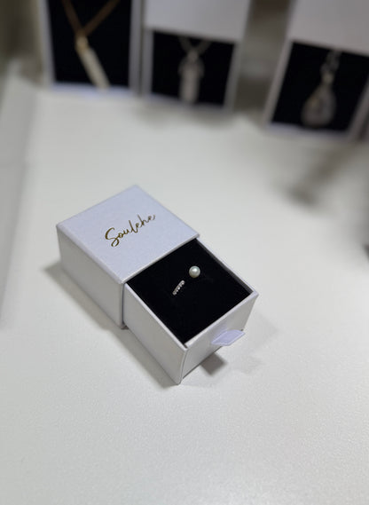 Earring in a branded box on a white surface