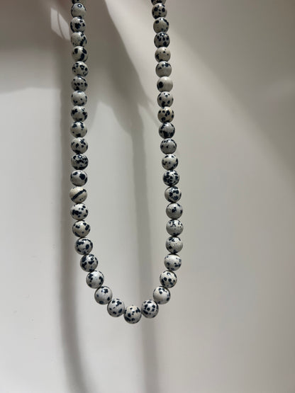 Beaded bracelet with black and white pattern on a light background