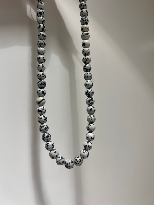 Beaded bracelet with black and white pattern on a light background