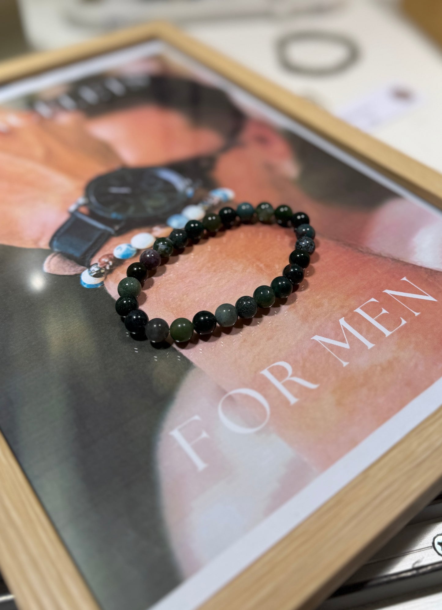 Black beaded bracelet on a magazine with 'For Men' text