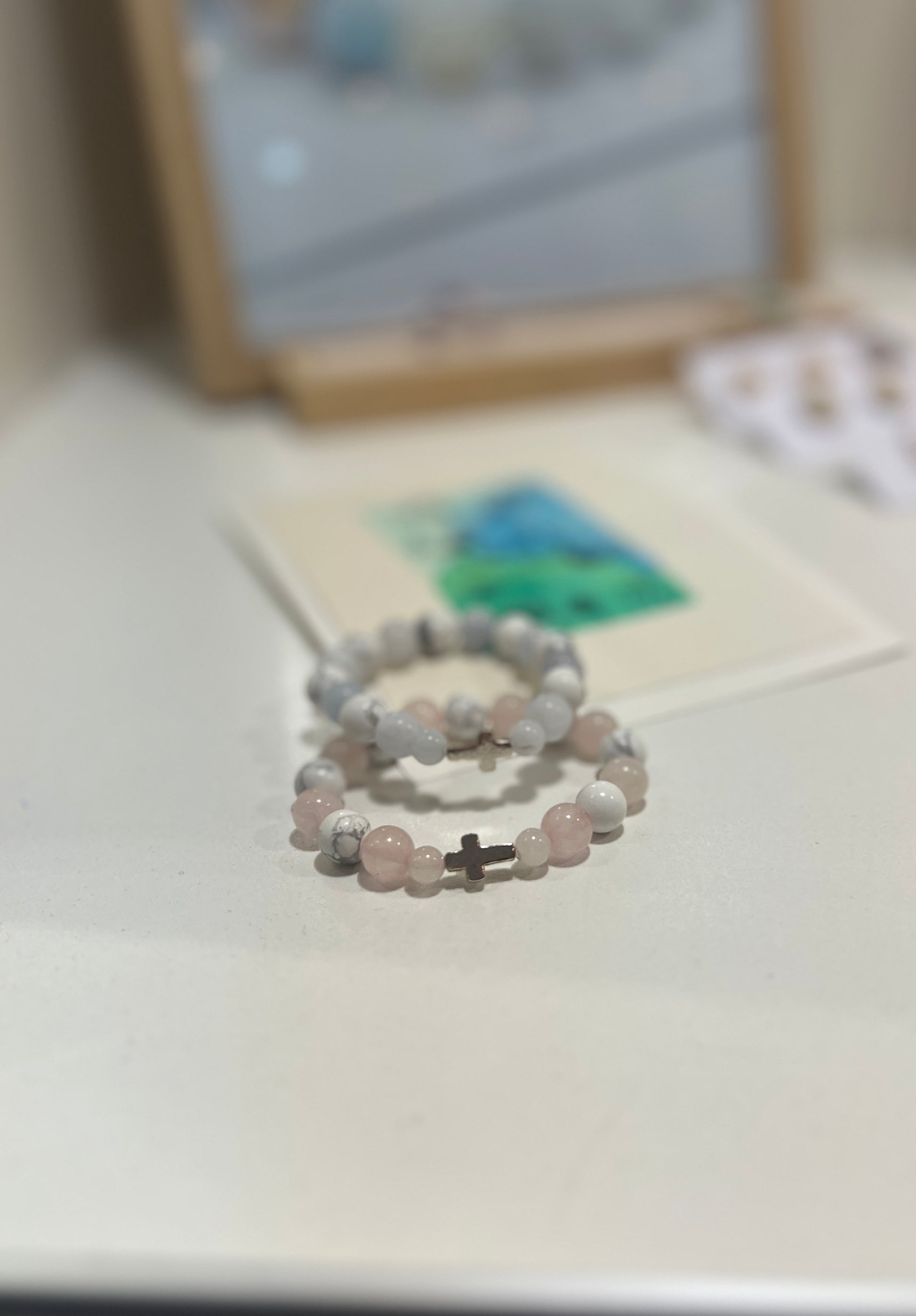 Two beaded bracelets on a light surface with a blurred background