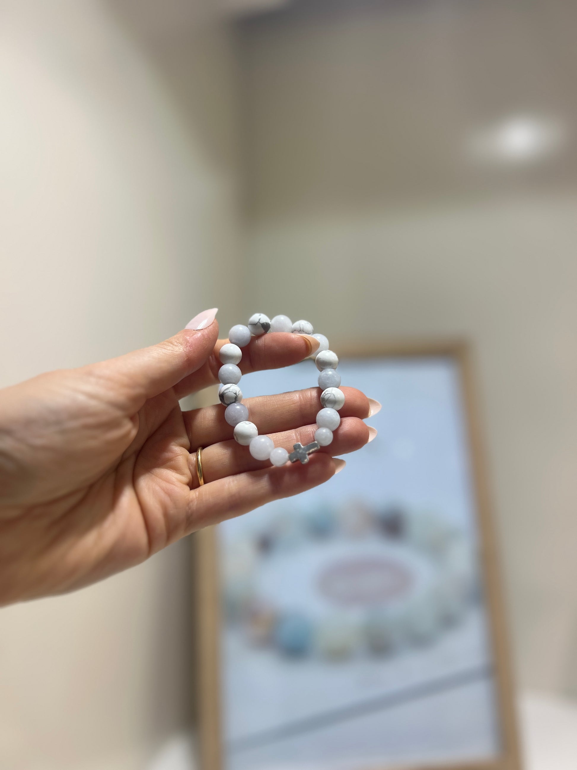 Hand holding a beaded bracelet with a blurred background