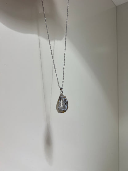 Silver necklace with a pendant on a white background
