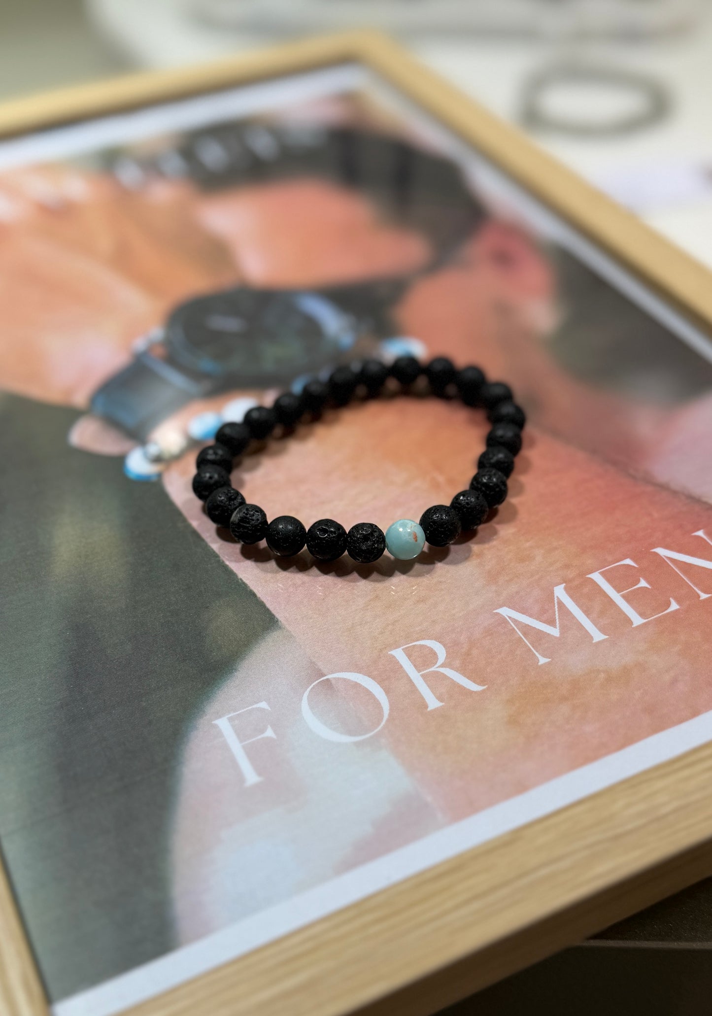 Black beaded bracelet on a magazine with 'For Men' text