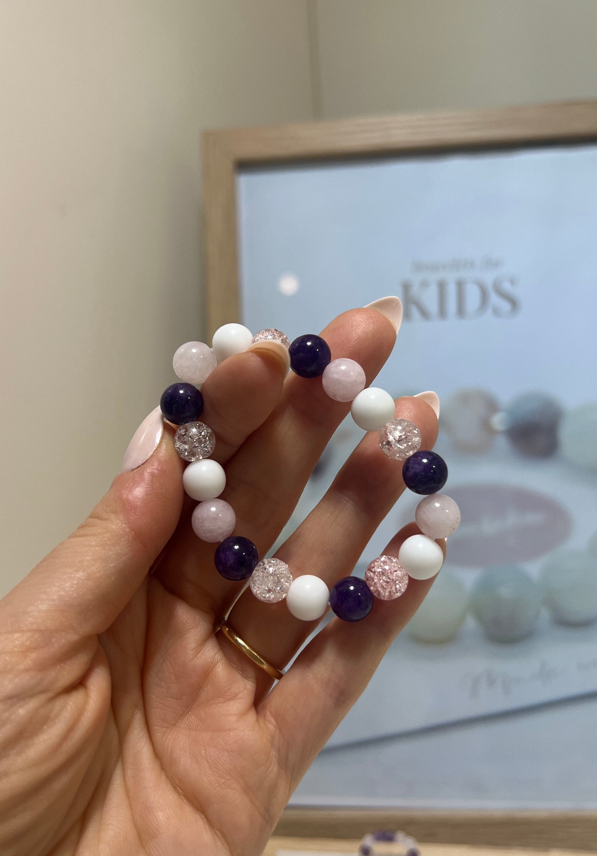Hand holding a beaded bracelet with a blurred background