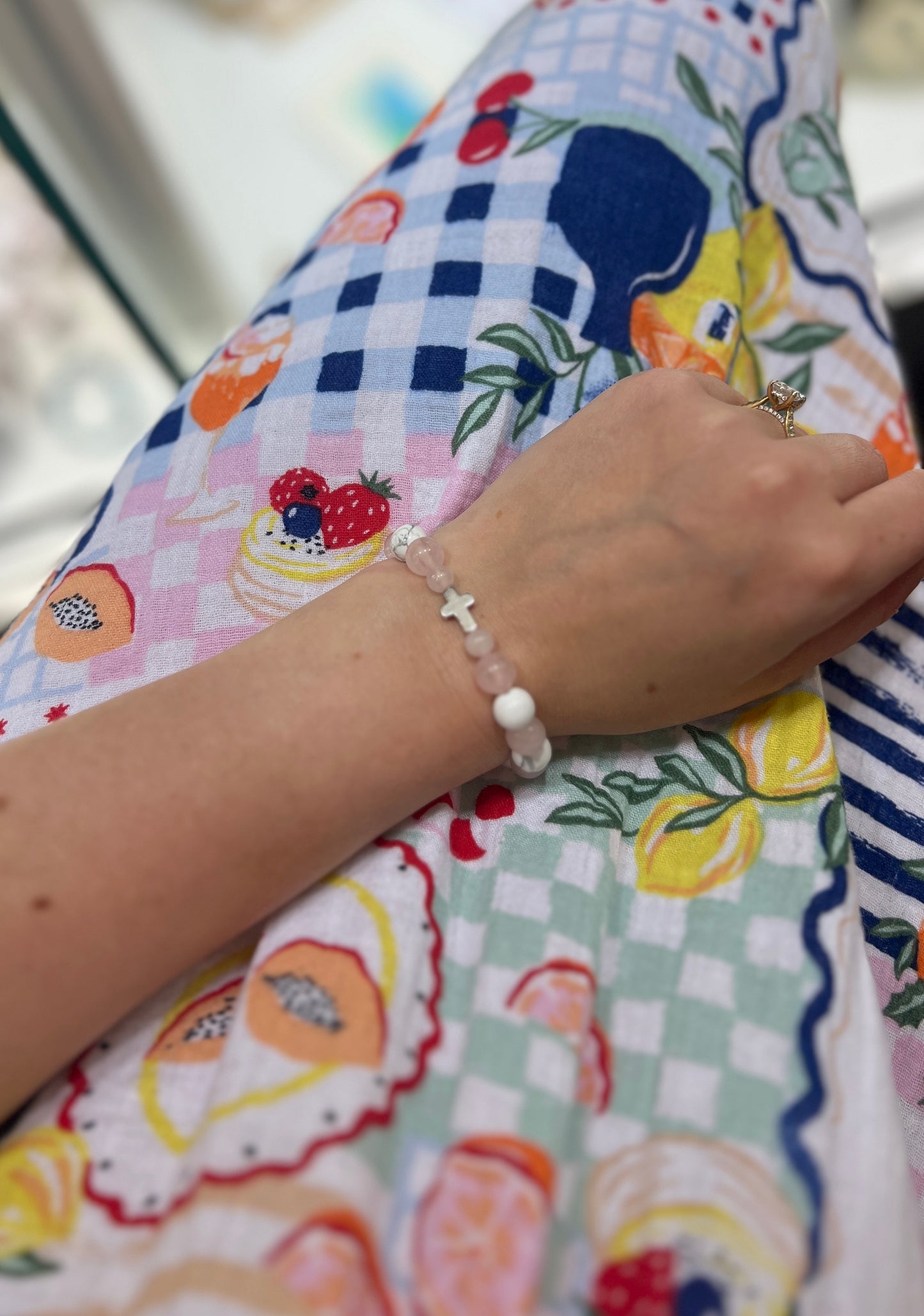 Close-up of a wrist wearing a bracelet on a colorful fabric background
