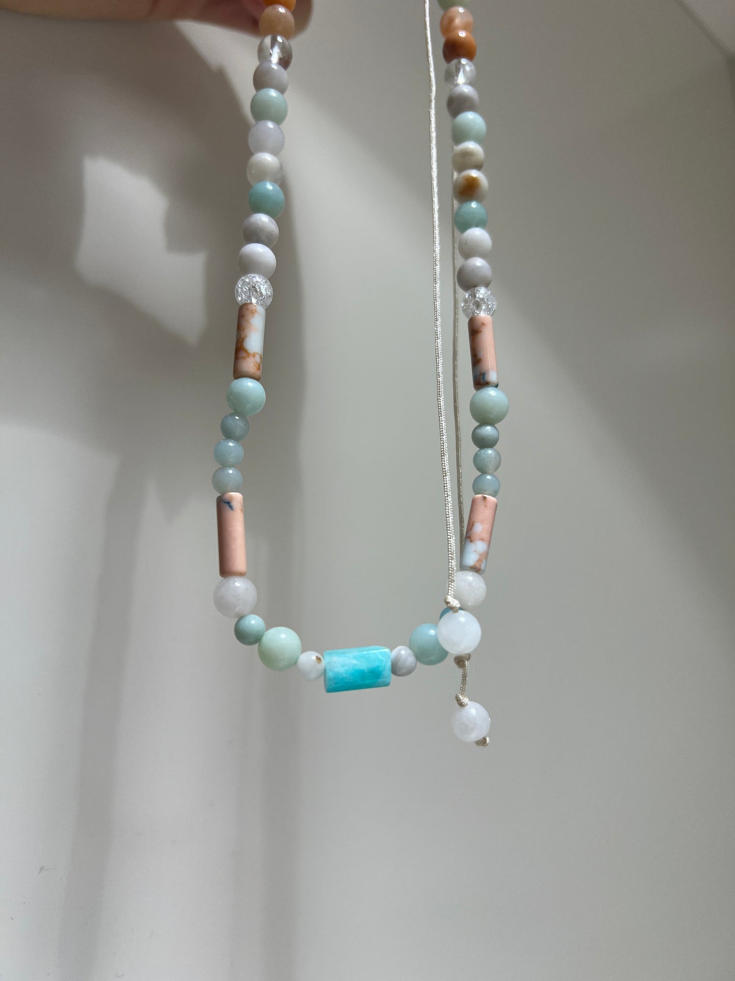 Beaded necklace with multicolored beads on a plain background