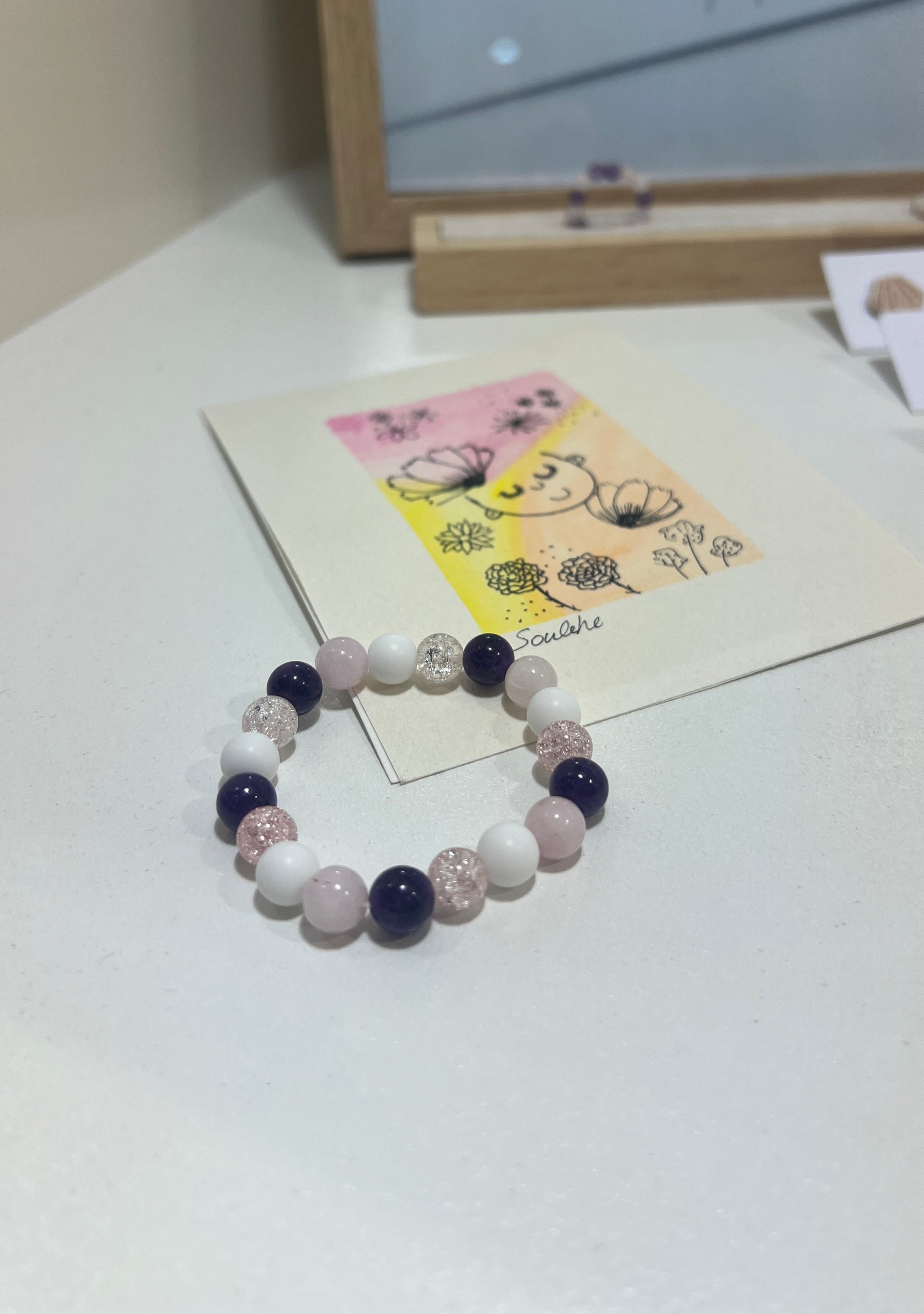 Beaded bracelet on a white surface with a small card featuring a cartoon character.