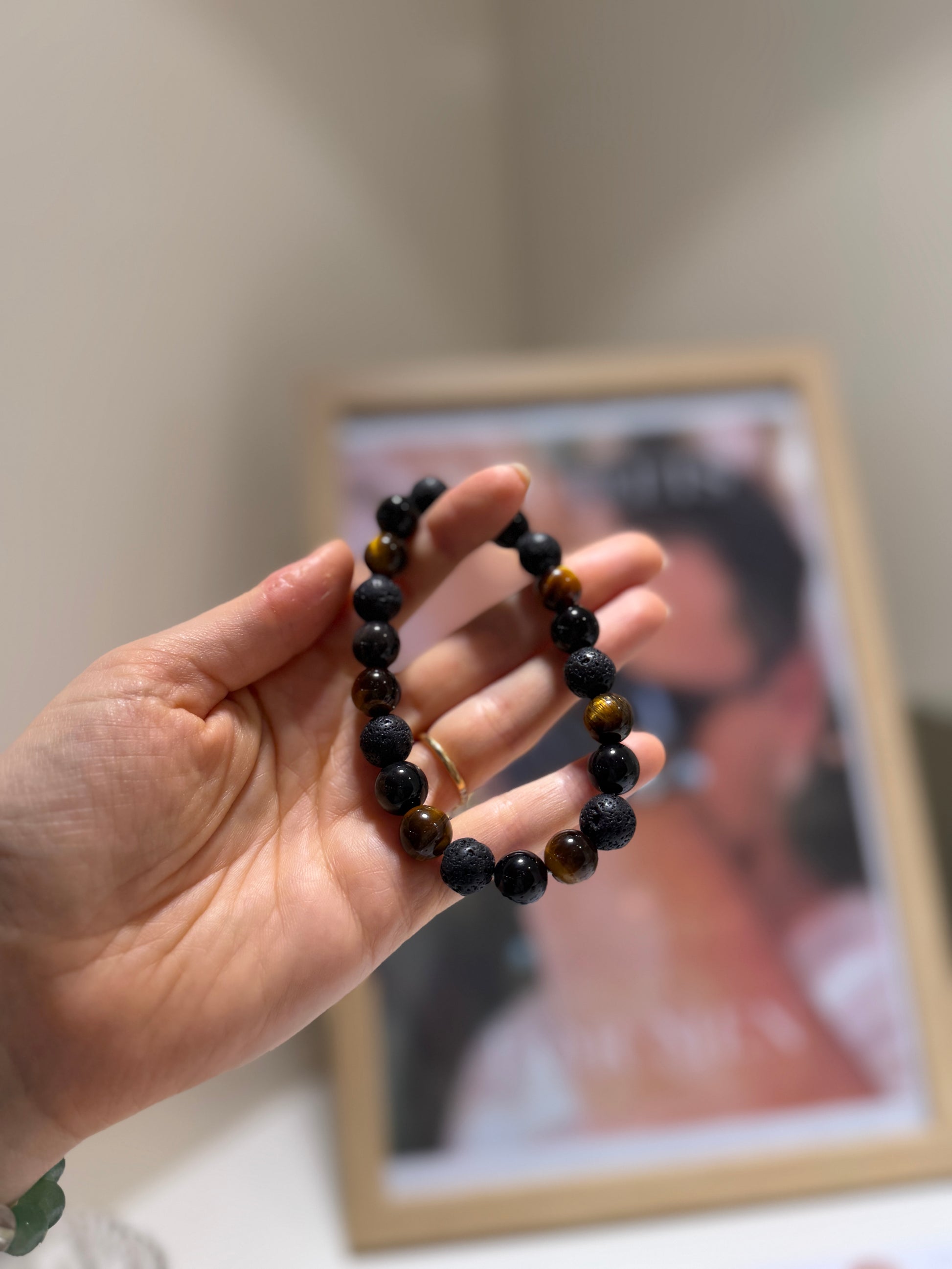 Hand holding a beaded bracelet with a blurred background