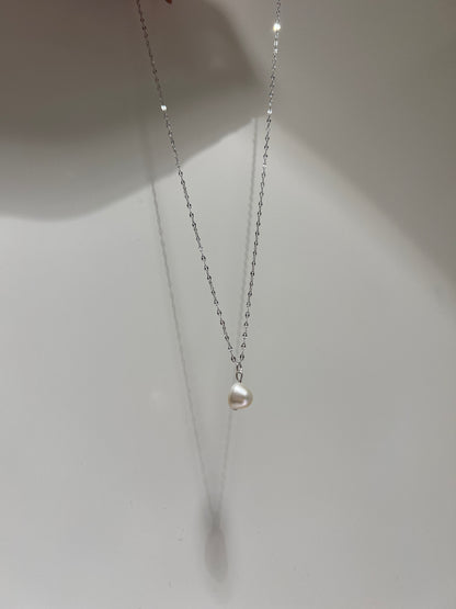 Silver chain with a pearl on a white background