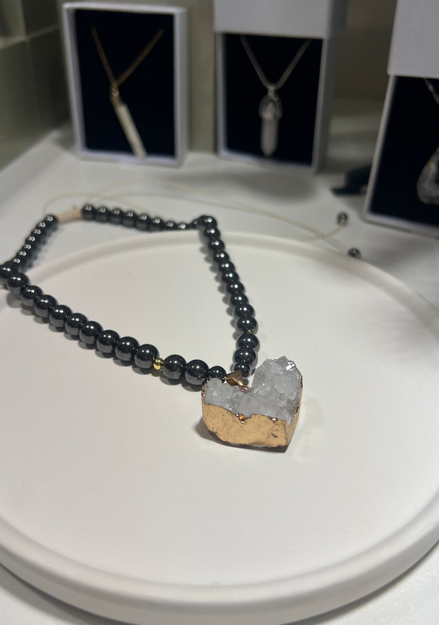 Black beaded necklace with a unique pendant on a white surface