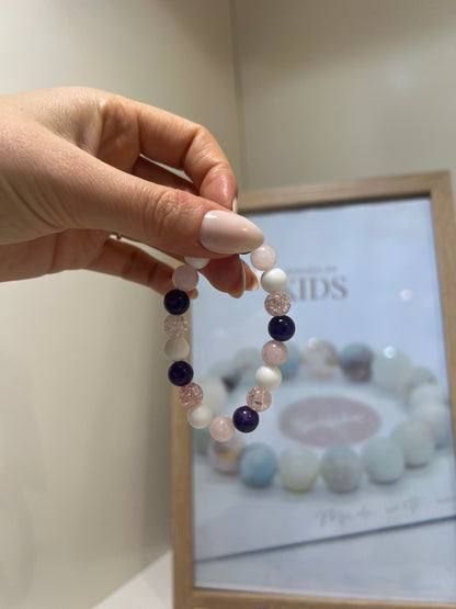 Hand holding a beaded bracelet with a blurred background