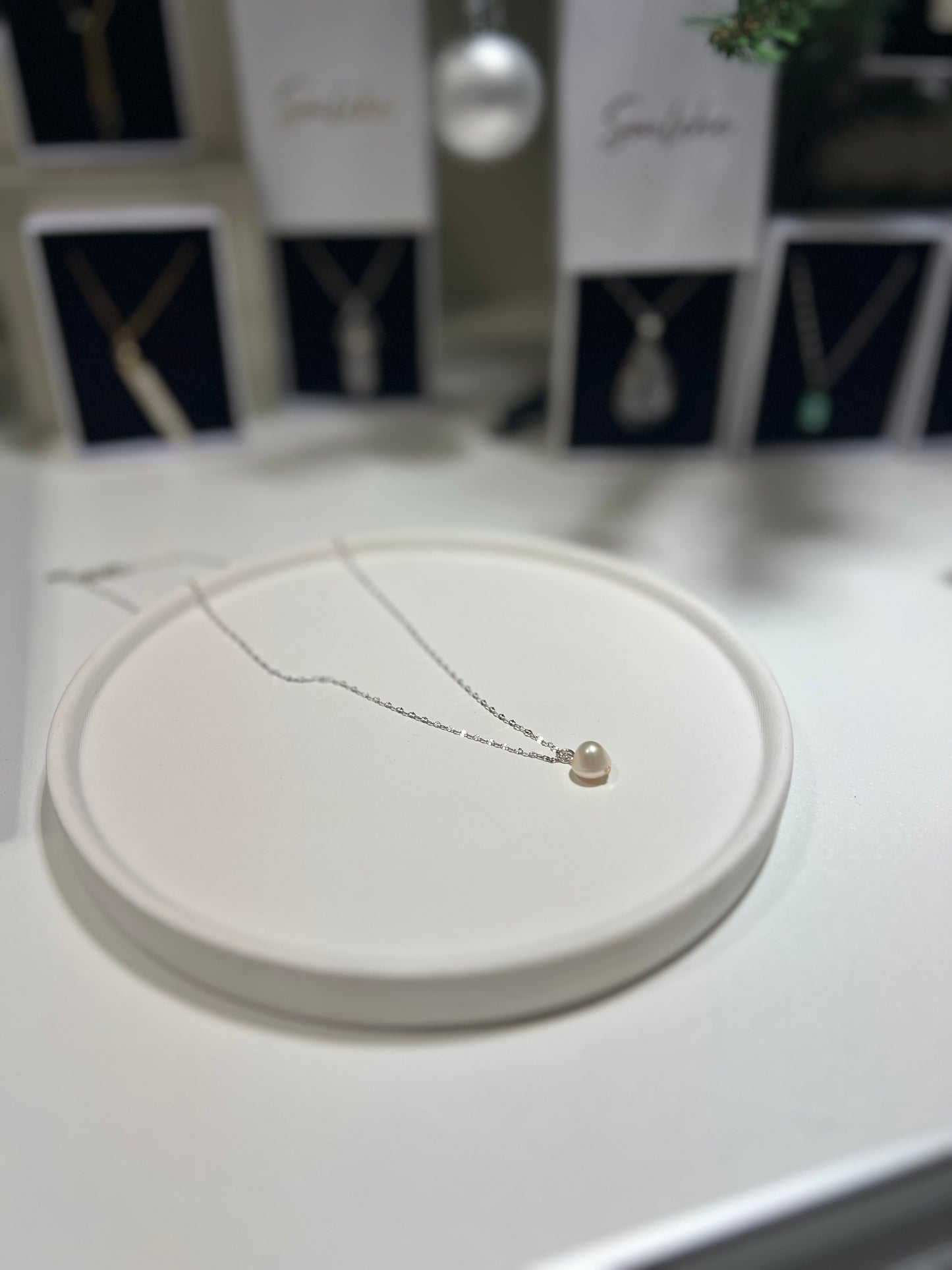 Necklace on a round beige stand with blurred background