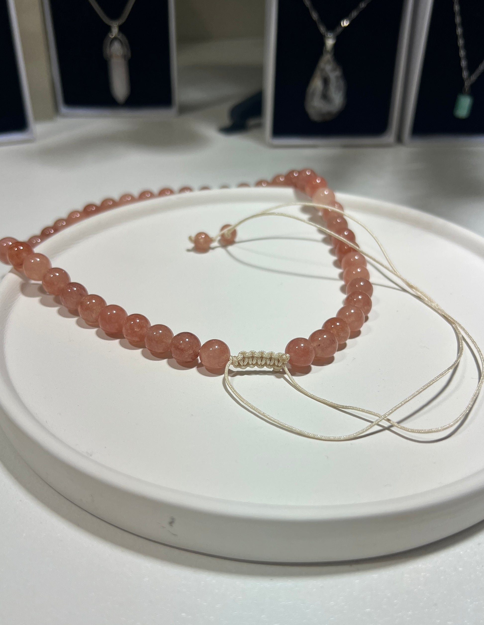 Necklace with pink beads on a white surface