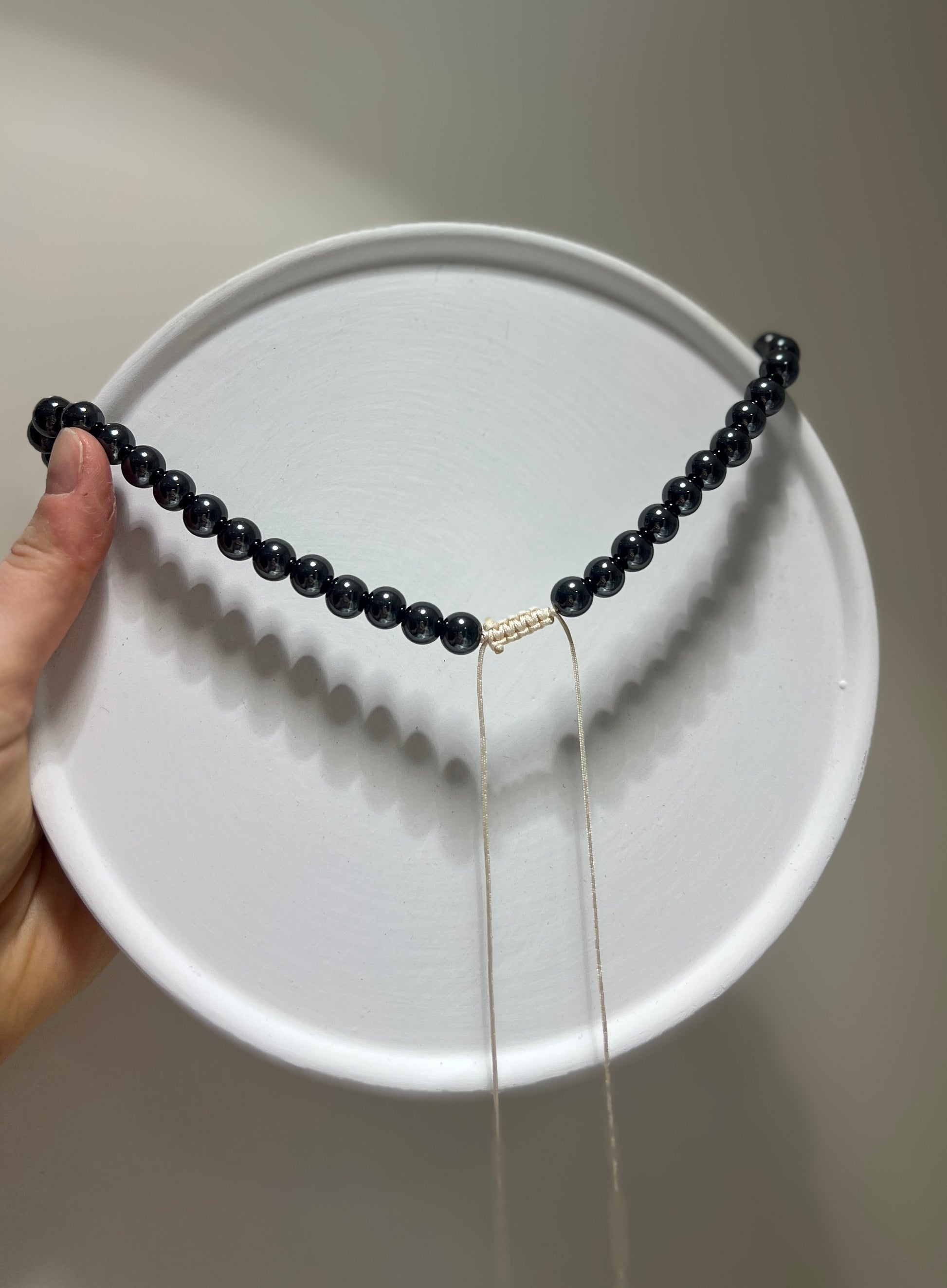 Black beaded necklace on a white plate
